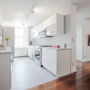 Foto di una cucina parallela minimal con ante lisce, ante bianche, elettrodomestici in acciaio inossidabile e nessuna isola