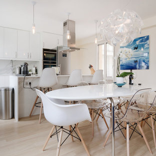 Inspiration pour une salle à manger ouverte sur la cuisine design de taille moyenne avec un mur blanc, un sol en bois clair et un sol beige.