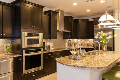 Example of a mid-sized transitional u-shaped porcelain tile and beige floor eat-in kitchen design in Los Angeles with an undermount sink, recessed-panel cabinets, dark wood cabinets, granite countertops, gray backsplash, matchstick tile backsplash, stainless steel appliances, an island and beige countertops
