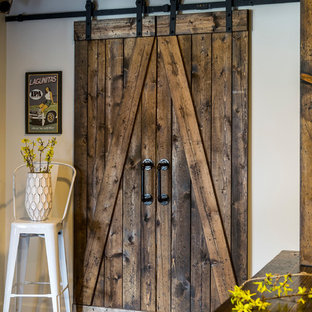 セントルイスの大きいカントリー風おしゃれな地下室 (半地下 (ドアあり)、白い壁、濃色無垢フローリング、標準型暖炉、レンガの暖炉まわり、茶色い床) の写真