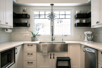 Example of a minimalist eat-in kitchen design in Toronto with shaker cabinets and white backsplash
