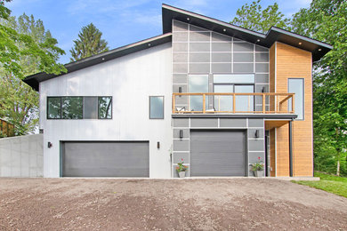 Inspiration for a mid-sized modern one-storey grey house exterior in Grand Rapids with mixed siding and a shed roof.