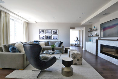 Mid-sized mid-century modern open concept medium tone wood floor and brown floor living room photo in Toronto with gray walls, a standard fireplace, a stone fireplace and a media wall
