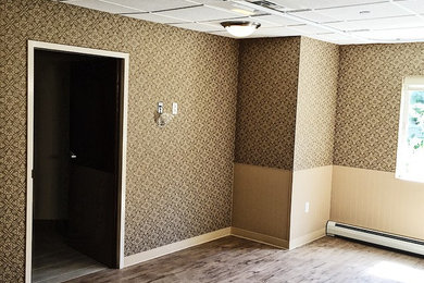 プロビデンスにある中くらいなトラディショナルスタイルのおしゃれなリビング (マルチカラーの壁、暖炉なし、茶色い床) の写真