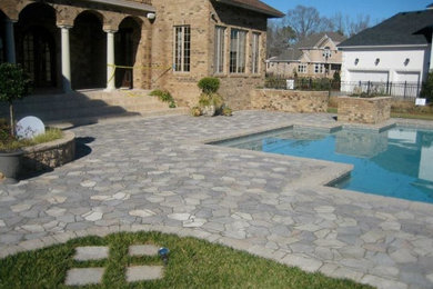 Large elegant backyard concrete paver and custom-shaped pool photo in Other