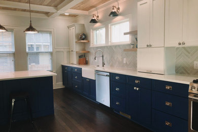 Example of a large arts and crafts u-shaped dark wood floor, brown floor and shiplap ceiling eat-in kitchen design in Indianapolis with a farmhouse sink, shaker cabinets, blue cabinets, quartzite countertops, gray backsplash, ceramic backsplash, stainless steel appliances, an island and white countertops