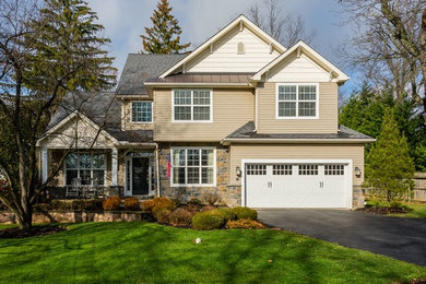 Example of a large classic beige two-story wood exterior home design in Philadelphia with a shingle roof