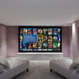 Idée de décoration pour une petite salle de cinéma design fermée avec un mur rose, moquette et un écran de projection.