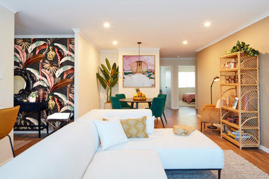 Imagen de salón abierto exótico de tamaño medio con paredes multicolor y suelo de madera en tonos medios