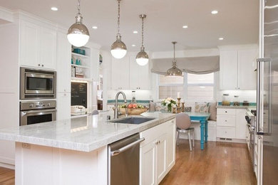 Inspiration for a large traditional u-shaped eat-in kitchen in Charlotte with an undermount sink, shaker cabinets, white cabinets, granite benchtops, white splashback, stainless steel appliances, medium hardwood floors and with island.