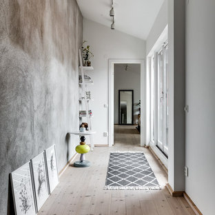Nordisk inredning av en stor hall, med grå väggar och ljust trägolv