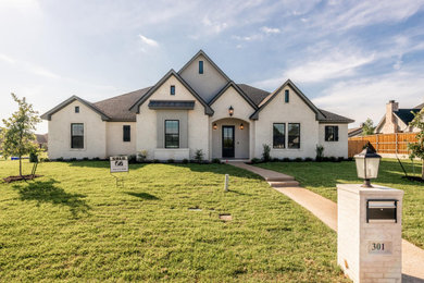 Arts and crafts white one-story brick exterior home photo in Austin with a shingle roof