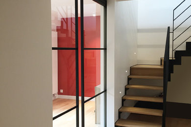 Inspiration pour une très grande entrée design avec un couloir, un mur blanc, parquet clair, une porte simple, une porte blanche et un sol beige.