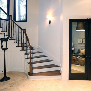 Cette photo montre une grande entrée éclectique avec un mur beige, une porte métallisée, un couloir, un sol en travertin et un sol beige.