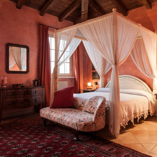 Large country master bedroom in Milan with red walls and terra-cotta floors.
