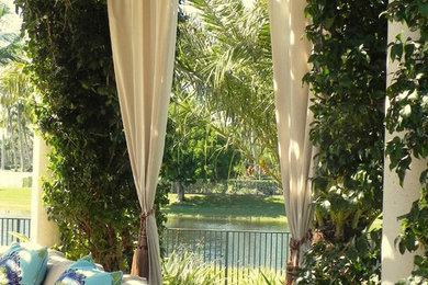 This is an example of a large mediterranean backyard patio in Miami with a pergola.