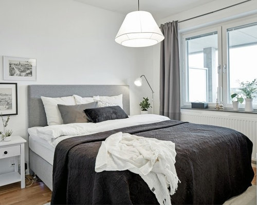 Inredning av ett nordiskt stort sovrum, med vita väggar och ljust trägolv