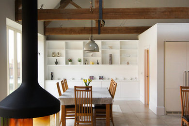 Design ideas for a large country open plan dining in Oxfordshire with beige floor and a wood stove.