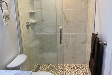 Mid-sized beach style multicolored tile and ceramic tile porcelain tile and single-sink sliding shower door photo in Miami with white walls, an undermount sink, multicolored countertops, a freestanding vanity, brown cabinets and marble countertops