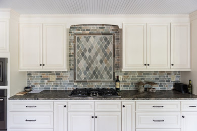 Open concept kitchen - large transitional u-shaped medium tone wood floor and brown floor open concept kitchen idea in Other with a double-bowl sink, raised-panel cabinets, white cabinets, granite countertops, gray backsplash, stone tile backsplash, stainless steel appliances, no island and gray countertops
