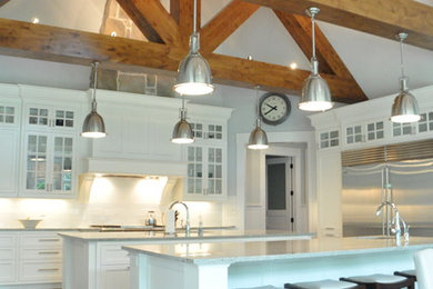 Inspiration for a large transitional l-shaped medium tone wood floor and brown floor eat-in kitchen remodel in Cleveland with an undermount sink, recessed-panel cabinets, white cabinets, marble countertops, white backsplash, subway tile backsplash, stainless steel appliances, two islands and white countertops