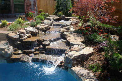 Pool fountain - traditional backyard stone and custom-shaped pool fountain idea in Oklahoma City