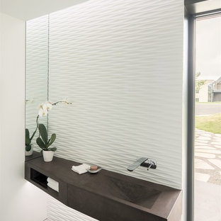 Foto di un bagno di servizio moderno di medie dimensioni con pareti bianche, parquet scuro, lavabo integrato e pavimento marrone