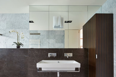 This is an example of an expansive contemporary master bathroom in Melbourne with flat-panel cabinets, dark wood cabinets, white tile, stone slab, white walls, marble floors, a wall-mount sink and marble benchtops.