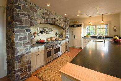 Kitchen pantry - large traditional u-shaped kitchen pantry idea in Burlington with an undermount sink, recessed-panel cabinets, granite countertops, stainless steel appliances, an island and black countertops
