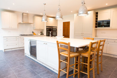Photo of a large traditional l-shaped kitchen/diner in Other with a double-bowl sink, shaker cabinets, grey cabinets, quartz worktops, stainless steel appliances, porcelain flooring, an island, grey floors and white worktops.
