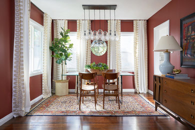 Inspiration for a mediterranean separate dining room in Los Angeles with red walls, dark hardwood floors and brown floor.