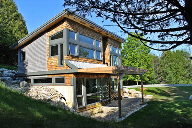 Mid-sized contemporary gray two-story wood house exterior idea in Ottawa with a shed roof and a metal roof