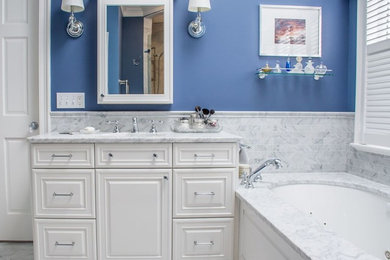 Large elegant master gray tile marble floor and gray floor bathroom photo in Cleveland with furniture-like cabinets, white cabinets, an undermount tub, blue walls and marble countertops