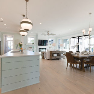 Idee per una grande sala da pranzo aperta verso il soggiorno country con pareti verdi, parquet chiaro, camino lineare Ribbon, cornice del camino in perlinato, pavimento grigio e pareti in perlinato