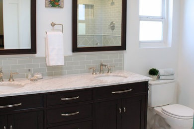 Design ideas for a mid-sized traditional master bathroom in San Francisco with shaker cabinets, dark wood cabinets, a corner shower, a two-piece toilet, green tile, porcelain tile, white walls, marble floors, an undermount sink and marble benchtops.