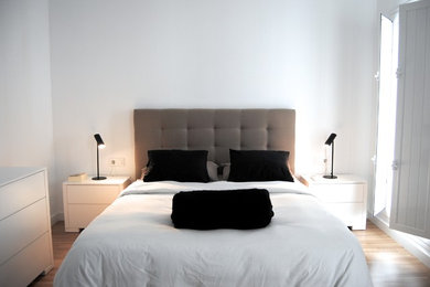 Imagen de dormitorio principal escandinavo de tamaño medio con paredes grises, suelo de madera en tonos medios y suelo marrón