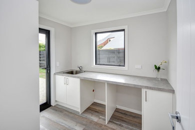 Example of a trendy laundry room design in Dunedin