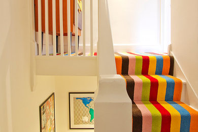 Photo of a modern painted wood straight staircase in London with painted wood risers.
