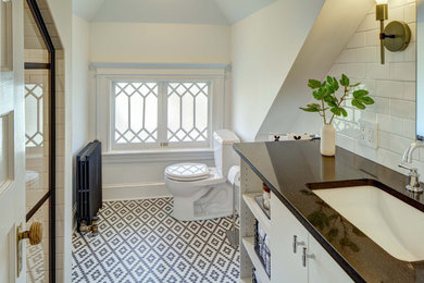 Идея дизайна: маленькая ванная комната в стиле неоклассика (современная классика) с белыми фасадами, душем в нише, раздельным унитазом, белой плиткой, керамической плиткой, белыми стенами, полом из керамогранита, врезной раковиной, столешницей из искусственного кварца, разноцветным полом, душем с распашными дверями, черной столешницей, тумбой под одну раковину и встроенной тумбой для на участке и в саду
