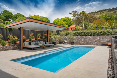Design ideas for an expansive contemporary back rectangular swimming pool in Canberra - Queanbeyan with with pool landscaping and tiled flooring.