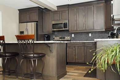 Inspiration for a contemporary l-shaped kitchen remodel in Toronto with shaker cabinets, gray cabinets, quartzite countertops, gray backsplash, stainless steel appliances and an island