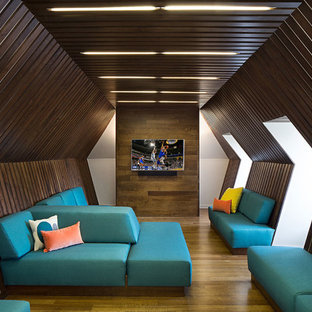 Example of a mid-sized trendy enclosed medium tone wood floor home theater design in Nashville with brown walls and a wall-mounted tv