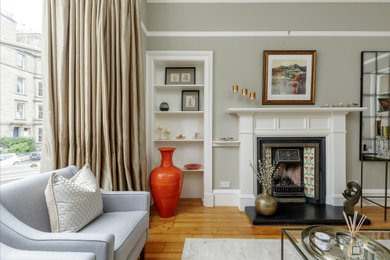 Medium sized traditional formal living room in Edinburgh with grey walls, medium hardwood flooring, a standard fireplace and brown floors.