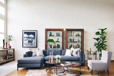 Example of a large trendy formal and open concept medium tone wood floor and brown floor living room design in Albuquerque with white walls, no fireplace and no tv