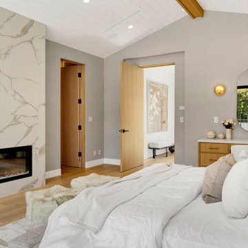Primary bedroom under a vaulted beamed ceiling