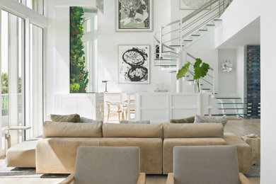 Example of a huge beach style open concept vaulted ceiling living room design in Miami with white walls