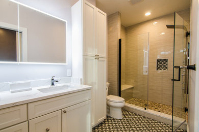 Contemporary bathroom in DC Metro with shaker cabinets, white cabinets, an alcove shower, beige tile, ceramic tile, white walls, porcelain floors, an undermount sink, engineered quartz benchtops, a hinged shower door and white benchtops.