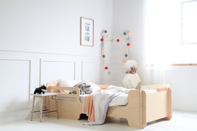 This is an example of a contemporary gender-neutral kids' bedroom for kids 4-10 years old in Melbourne with white walls, light hardwood floors and white floor.