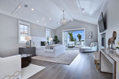 Large trendy master medium tone wood floor and brown floor bedroom photo in Los Angeles with gray walls and a standard fireplace