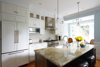 Eat-in kitchen - transitional medium tone wood floor eat-in kitchen idea in DC Metro with a farmhouse sink, recessed-panel cabinets, white cabinets, granite countertops, white backsplash, subway tile backsplash, stainless steel appliances and an island